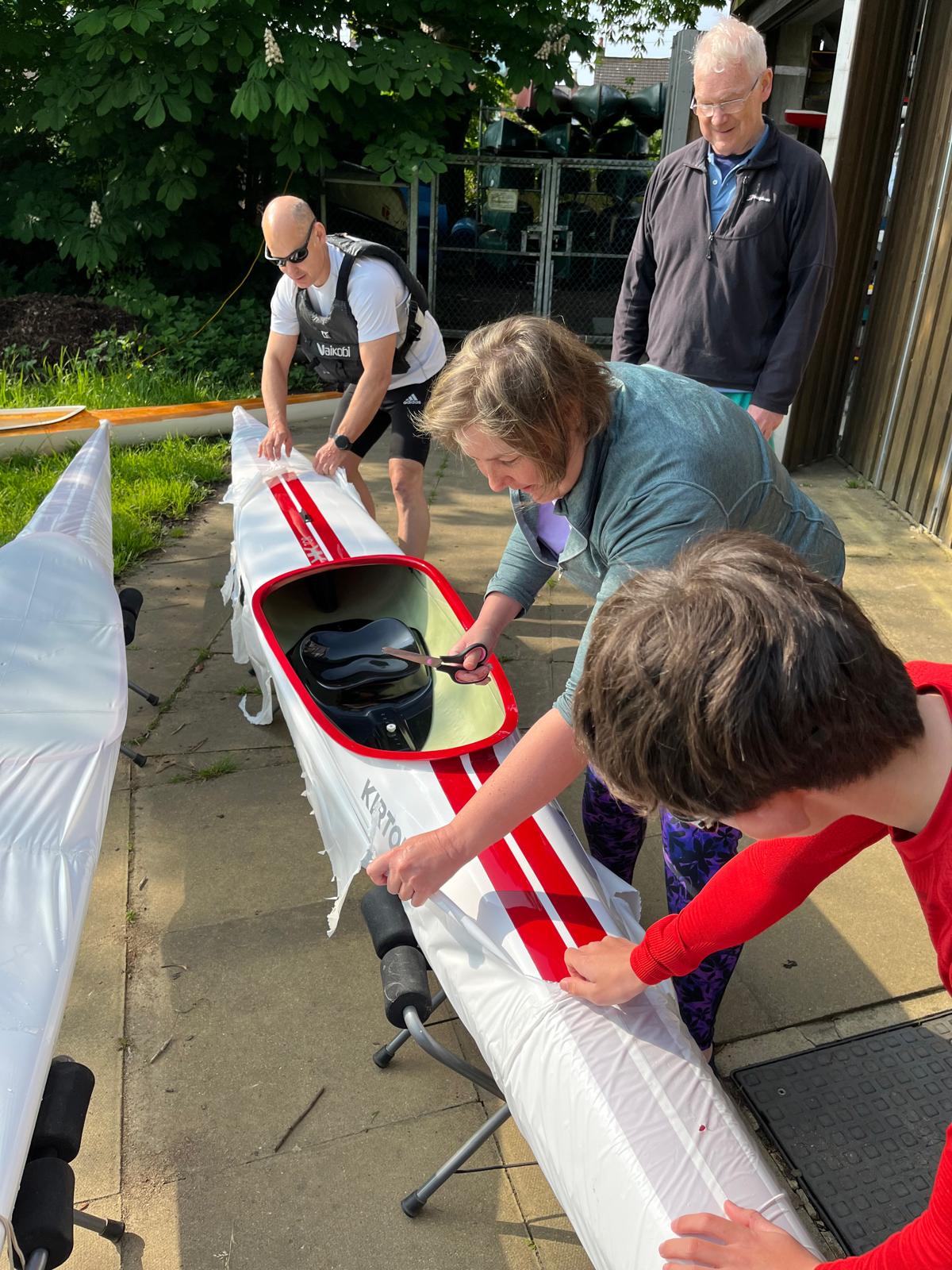 Adventure Dolphin members unwrap a new kayak